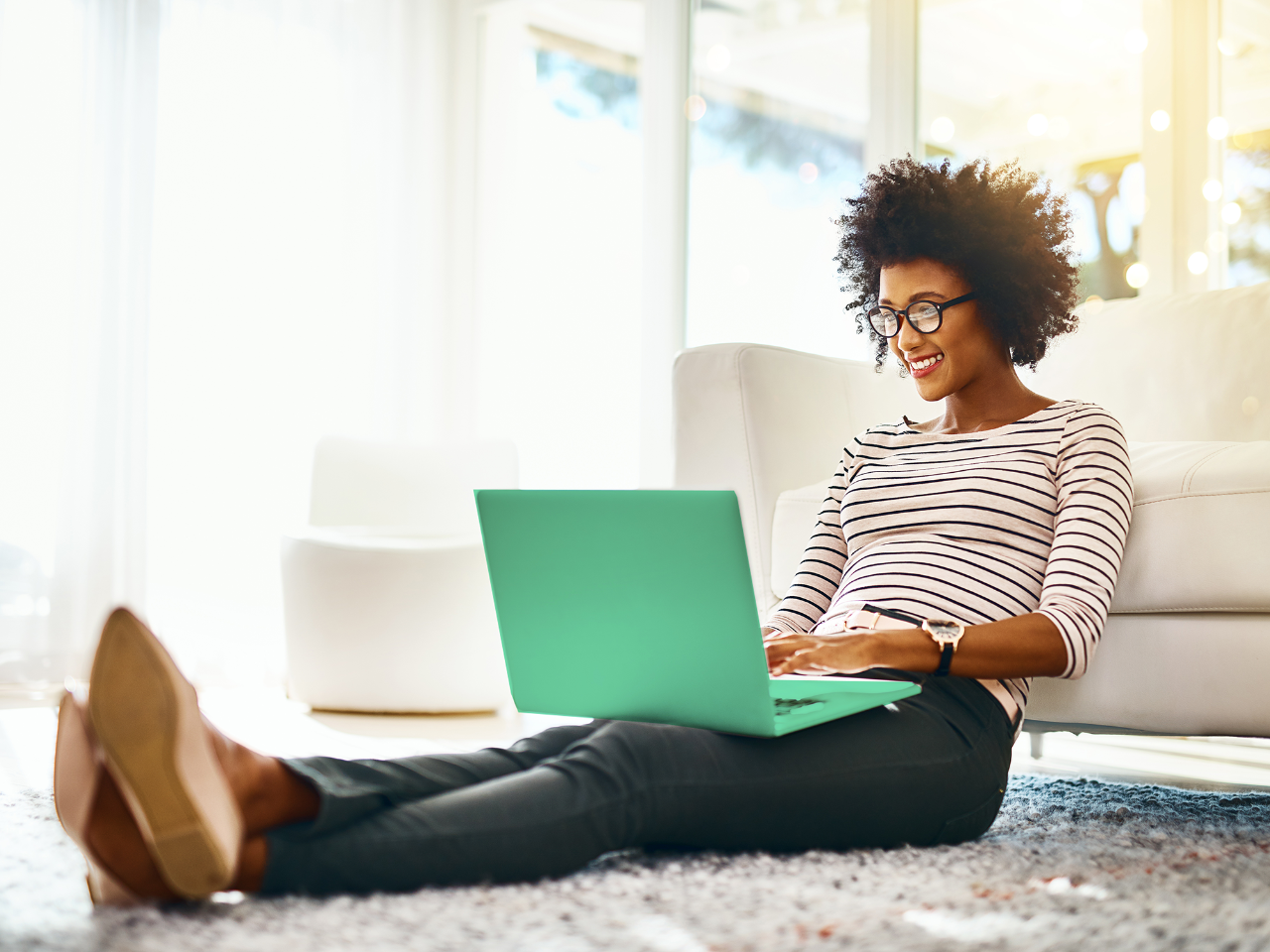Woman sits on the floor WFH on laptop