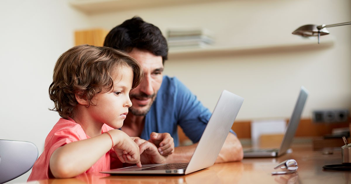 dad looking at laptop with kid
