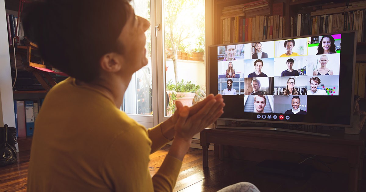 A young man laughs while video chatting on his smart TV
