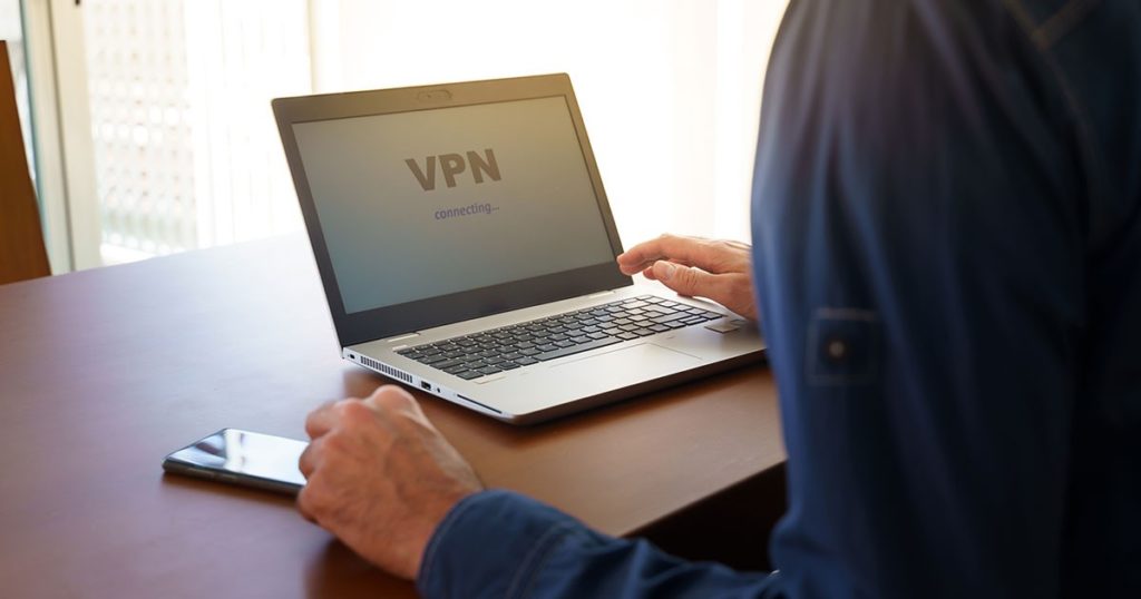 A person connects to the VPN on their laptop, which can help keep their data encrypted.