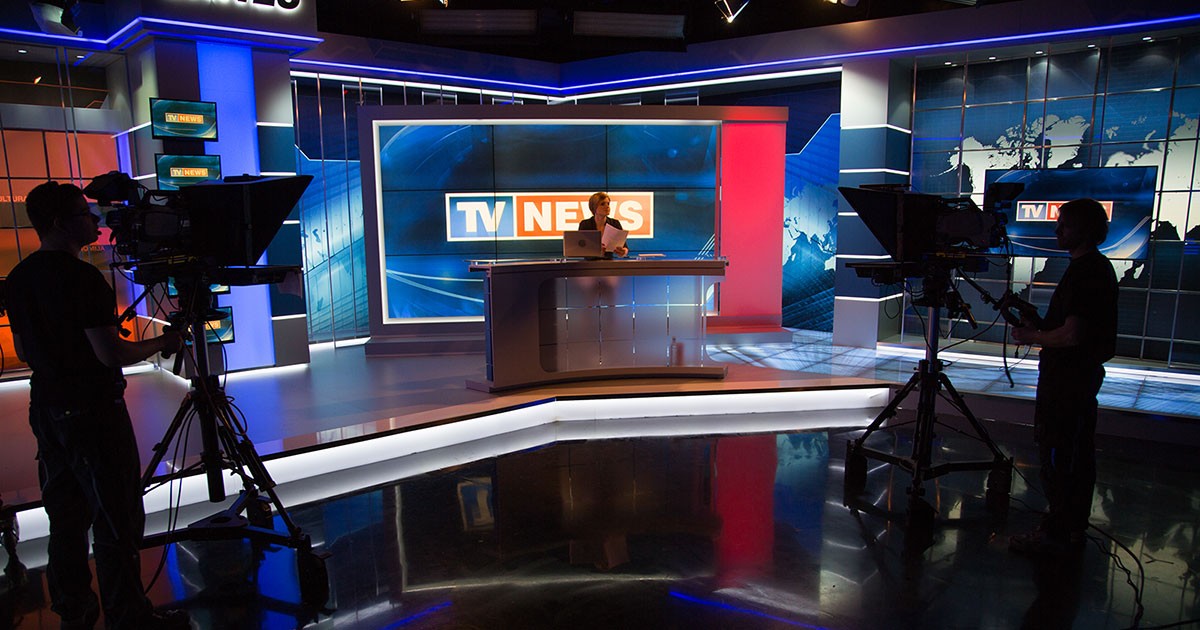 A news anchor reports the news from a television studio