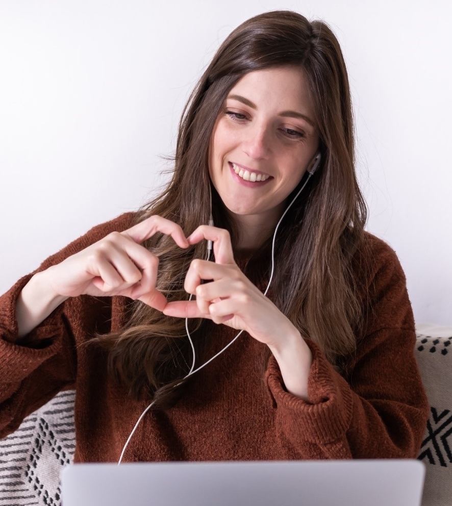 Woman video chatting makes a heart with her hands