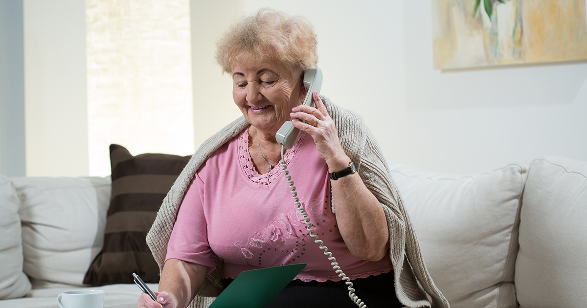 Senior woman chats on landline phone, landlines for seniors