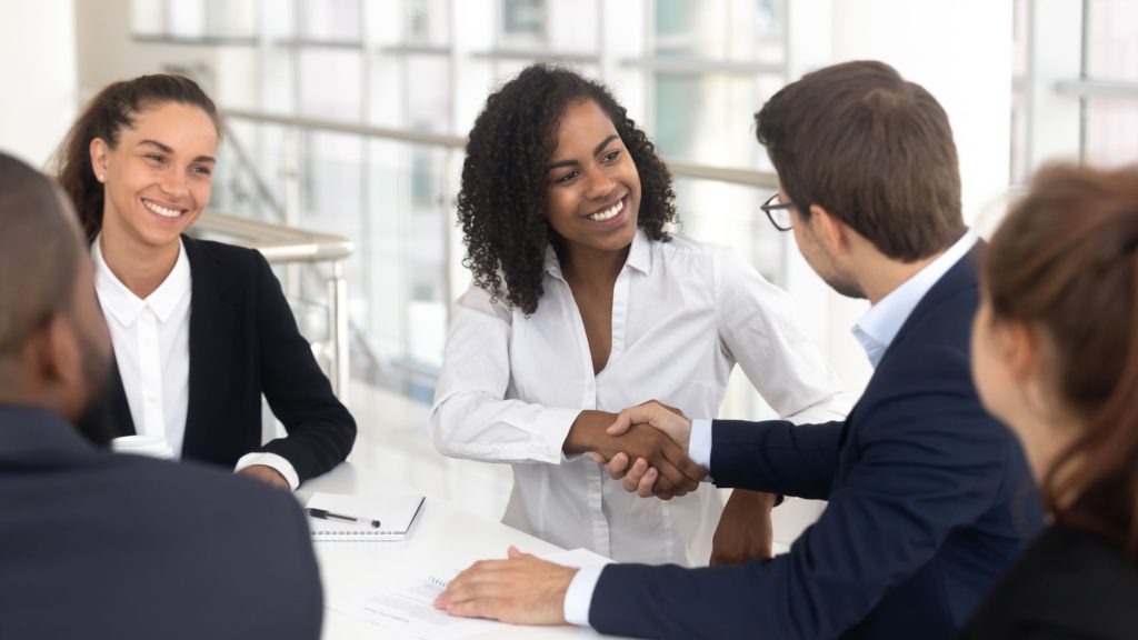 Two professionals shake hands during a business meeting. 