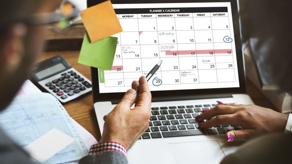 A small business teams uses a calendar to coordinate their schedules in a flexible hybrid working model.