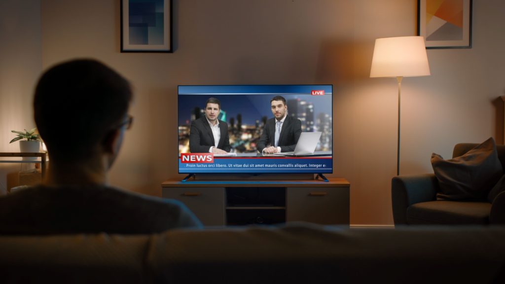 A man streams news on his smart TV.