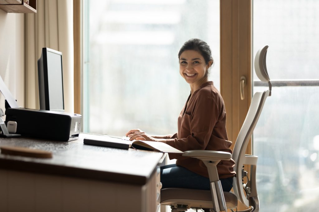 Woman uses a smart desk in her smart home office.