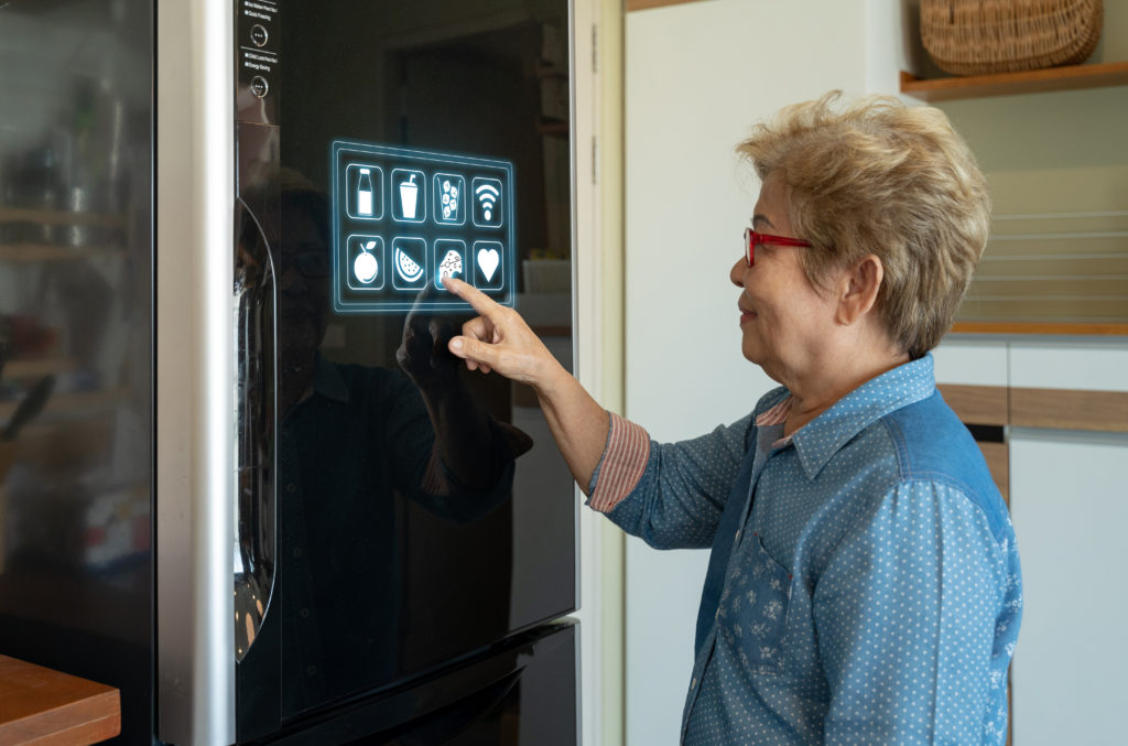 Woman using her smart kitchen fridge