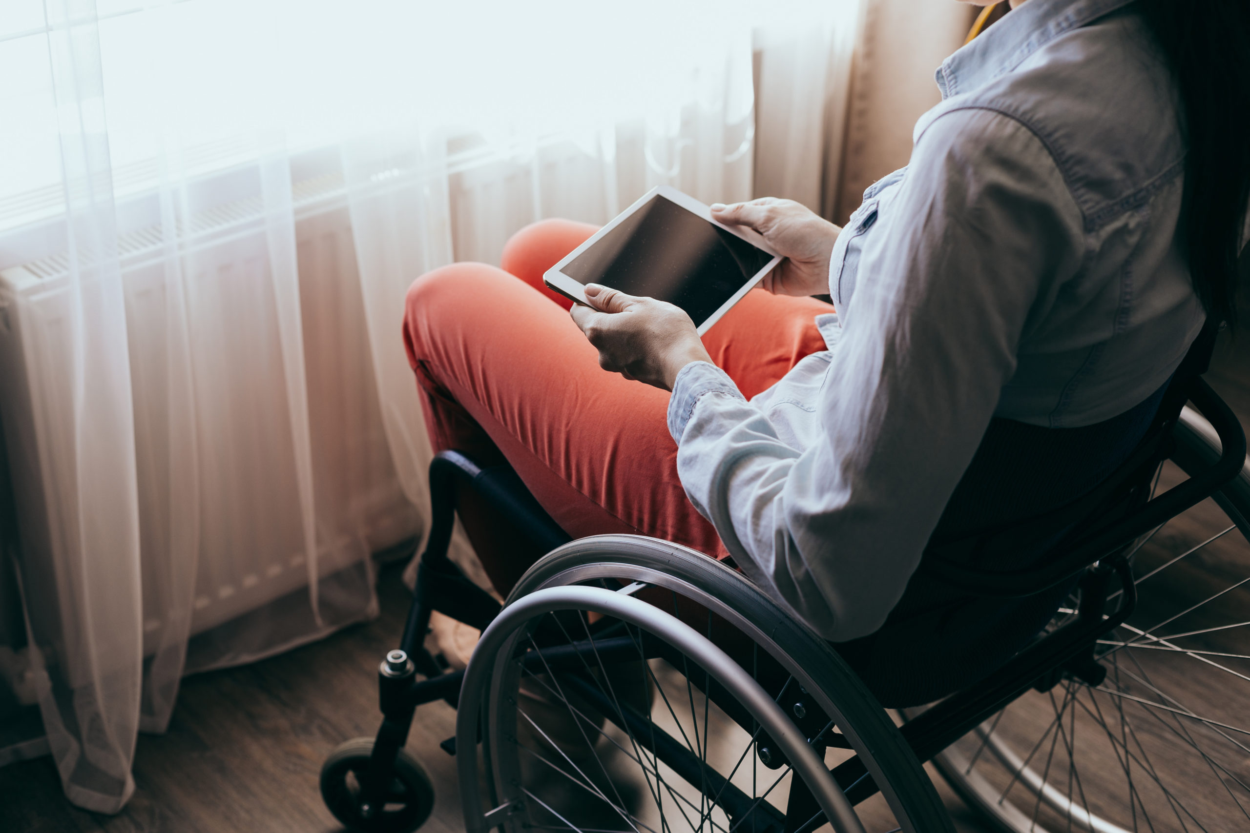 Person in a wheelchair using assistive devices