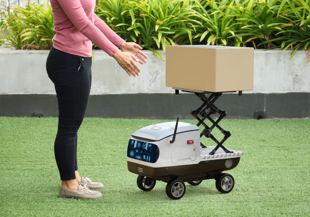 Woman taking a package from a delivery robot