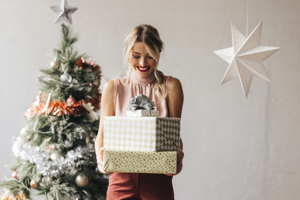 Woman holding stack of Christmas presents