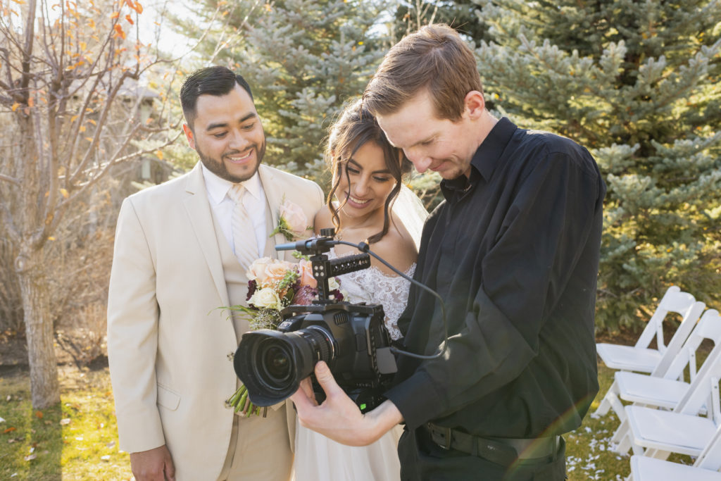 Photographer showing bride and groom wedding photos