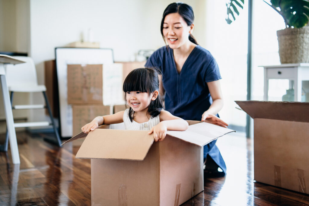 Woman playing with daughter in moving box