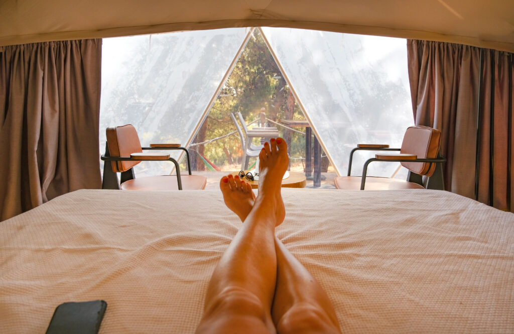 Woman's legs sitting in glamping tent